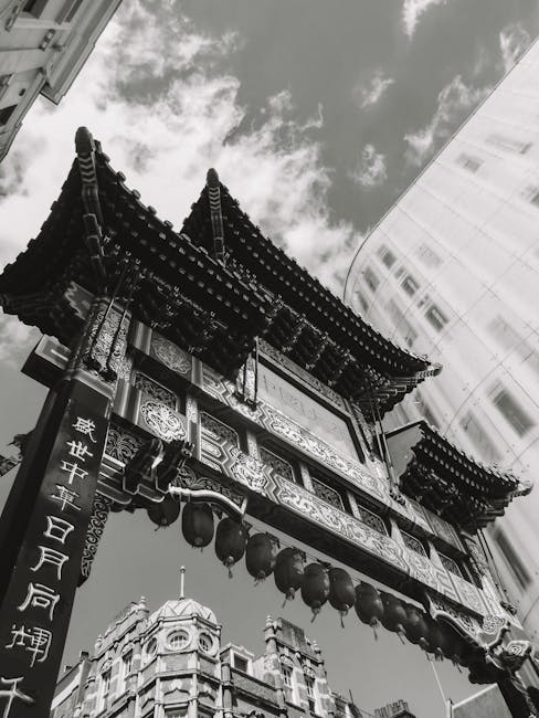 The image features a traditional Chinese pagoda-style structure with ornate, layered eaves and intricate decorative woodwork. The building is adorned with hanging red lanterns along its lower edge, co